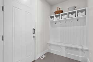 Mudroom with dark tile patterned floors