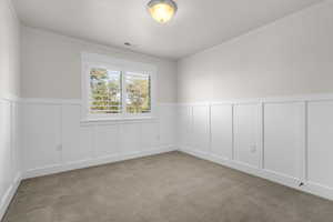 Carpeted spare room featuring ornamental molding