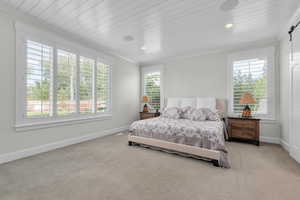 Primary Bedroom with multiple windows, ornamental molding, and light carpet