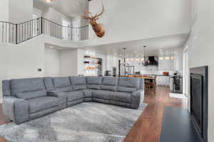 Living room featuring a high ceiling, dark hardwood / wood-style flooring, and a chandelier