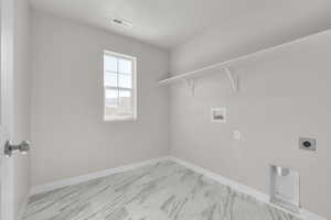 Washroom featuring hookup for a washing machine, a textured ceiling, and electric dryer hookup