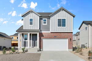 View of front facade with central AC and a garage