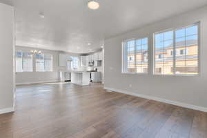 Unfurnished living room with light hardwood / wood-style floors and a healthy amount of sunlight