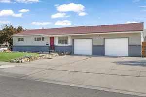 Ranch-style home with a garage and a front lawn