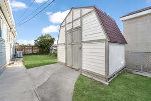 View of outbuilding with a yard and central air condition unit