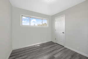 Empty room featuring dark hardwood / wood-style floors