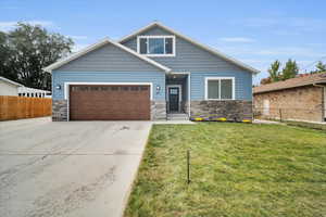 View of front of house featuring a front lawn and a garage