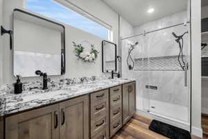 Primary Suite Bathroom featuring vanity, hardwood / wood-style floors, and an enclosed shower