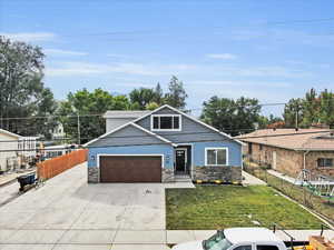 View of front of property with a garage and a front lawn