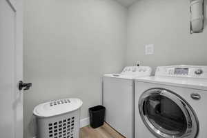 ADU Laundry room with light wood-type flooring and washing machine and dryer