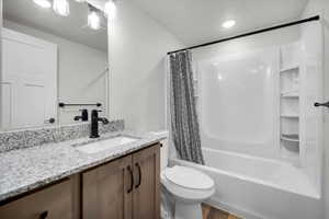 Full bathroom with shower / tub combo with curtain, vanity, toilet, and hardwood / wood-style flooring