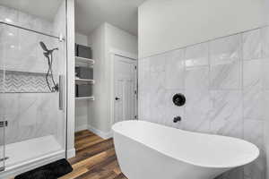 Primary Suite Bathroom with a textured ceiling, independent shower and bath, and hardwood / wood-style flooring