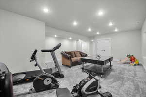 Basement Exercise room with light carpet