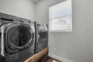 Main-Level Clothes washing area featuring dark wood-type flooring, independent washer and dryer, and a wealth of natural light