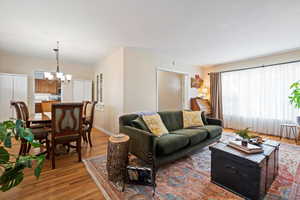 Living room with a notable chandelier and light wood-type flooring