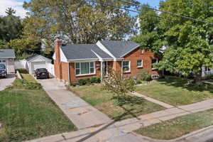 View of front of house featuring a front yard, an outbuilding, and a garage