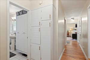 Corridor featuring ornamental molding, light hardwood / wood-style floors, and sink