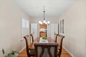 Dining space with light hardwood / wood-style floors and a chandelier