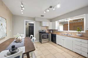 Kitchen with sink, white cabinetry, rail lighting, decorative backsplash, and black appliances