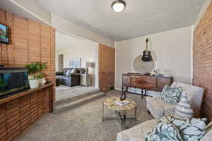 Carpeted living room with brick wall