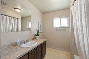 Bathroom featuring vanity, tile patterned floors, and a wealth of natural light