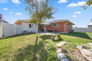 Rear view of house featuring a patio, a yard.