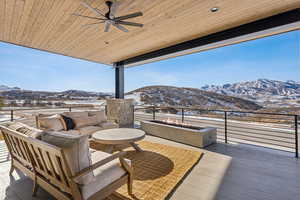 Snow covered deck featuring a mountain view, ceiling fan, and an outdoor hangout area