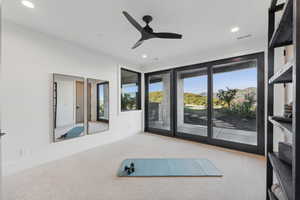 Exercise area featuring ceiling fan and carpet