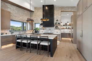 Kitchen featuring a kitchen breakfast bar, backsplash, light hardwood / wood-style flooring, and a kitchen island