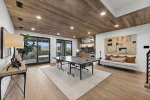 Game room with light wood-type flooring and wood ceiling