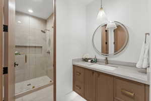 Bathroom with tile patterned floors, vanity, and a shower with shower door