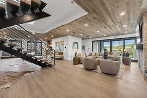 Living room featuring a fireplace, wood ceiling, and light hardwood / wood-style flooring