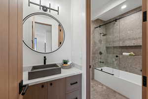 Bathroom with vanity and enclosed tub / shower combo