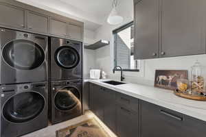 Laundry area with stacked washer / drying machine, cabinets, independent washer and dryer, and sink