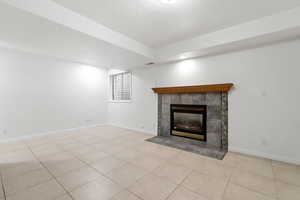 Unfurnished family room featuring light tile patterned floors and a fireplace