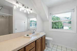 Upstairs bathroom with tiled floor, full tub, vanity, toilet, and tile patterned floors