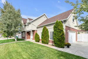 View of front of property featuring a front lawn and a garage