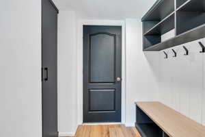 Mudroom with light LVP flooring and built in storage