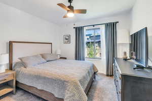 Carpeted bedroom featuring ceiling fan