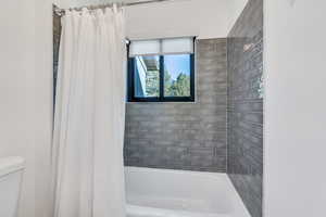 Bathroom featuring toilet and shower / bath combo.