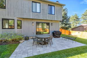 Back of property featuring a lawn and a patio area