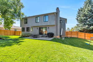 Rear view of house featuring a patio area and a yard