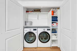 Laundry room with hardwood / wood-style floors and washer and dryer