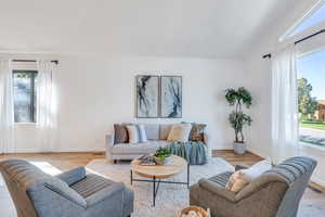 Living room with lofted ceiling and full of natural light.