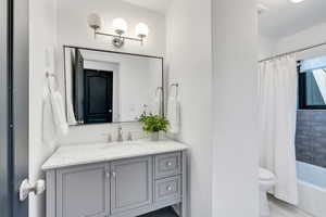 Full bathroom featuring vanity, toilet, and shower / tub combo.