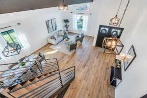 Living room featuring an inviting chandelier, high vaulted ceiling, and hardwood / wood-style flooring