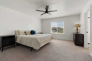 Carpeted bedroom with ceiling fan and a textured ceiling