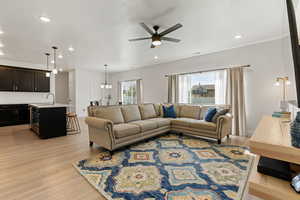 Living room with ceiling fan, light hardwood / wood-style flooring, and sink