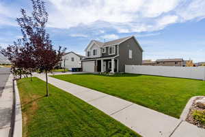 View of front of property featuring a garage and a front lawn