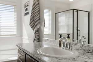 Bathroom with vanity and a shower with door